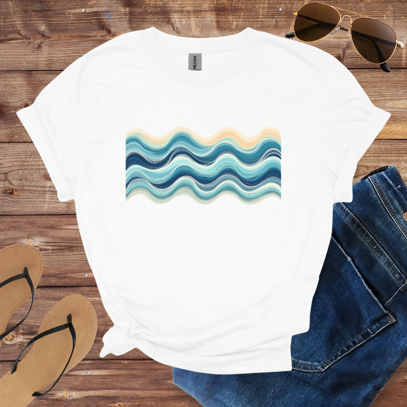 White t-shirt with wavy blue and beige design on a wooden surface with sunglasses, jeans, and flip-flops.