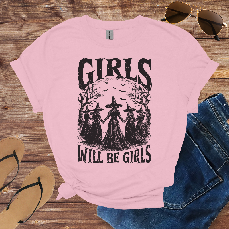 Light pink t-shirt with a graphic of four witches and the text "Girls Will Be Girls."