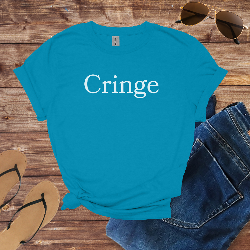 Blue t-shirt with 'Cringe' text on a wooden surface with sunglasses, jeans, and flip-flops.