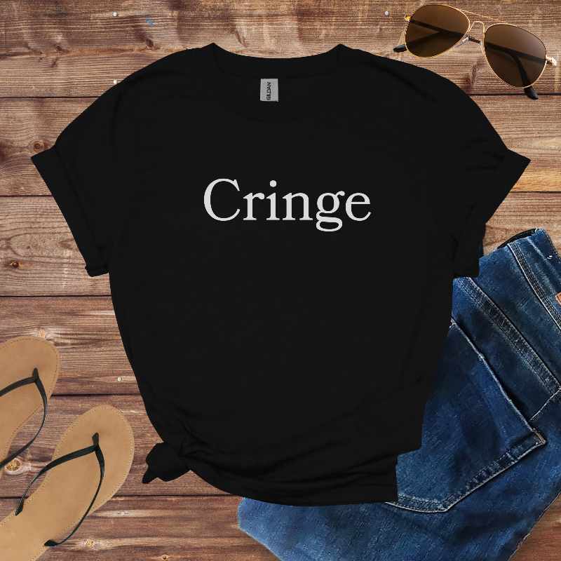 Black t-shirt with 'Cringe' text on a wooden surface with jeans, sunglasses, and sandals.
