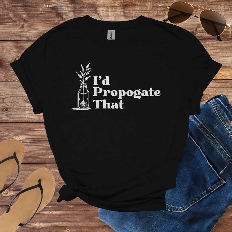 Black t-shirt with 'I'd Propogate That' text and plant graphic on a wooden surface with sunglasses, jeans, and flip-flops.