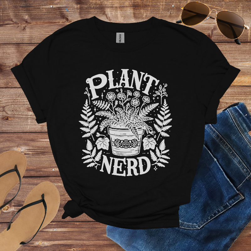 Black t-shirt with 'Plant Nerd' design on a wooden surface with sunglasses, jeans, and sandals.