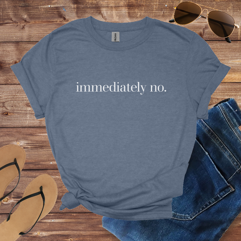 Blue t-shirt with 'immediately no.' text on a wooden surface with sunglasses, jeans, and sandals.