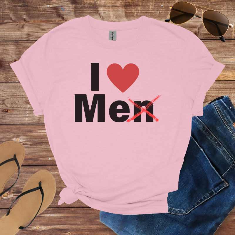 Pink t-shirt with 'I ❤️ Men' text on a wooden surface with sunglasses, jeans, and sandals.