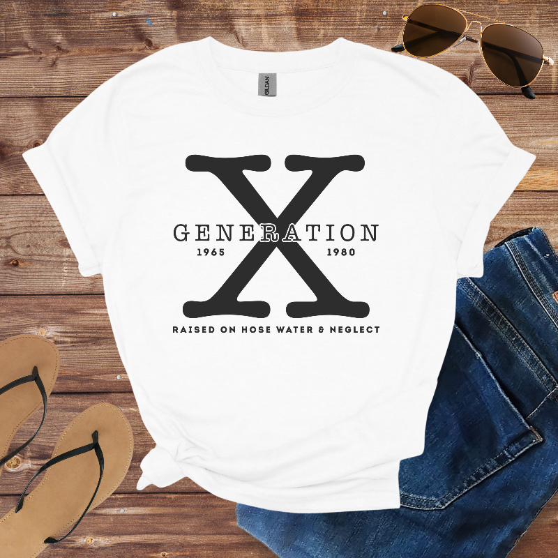 White t-shirt with 'Generation X' design on a wooden surface with sunglasses, jeans, and flip-flops.