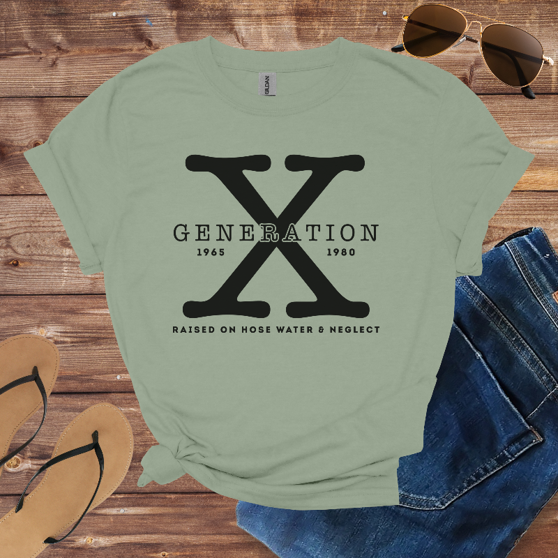 Green t-shirt with 'Generation X' design on a wooden surface with sunglasses, jeans, and flip-flops.