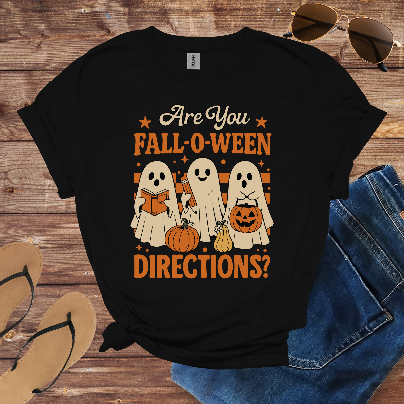 Black t-shirt with Halloween-themed design on a wooden surface with sunglasses and jeans.
