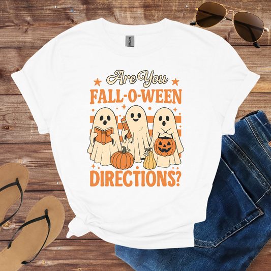 White t-shirt with Halloween-themed design featuring ghosts and pumpkins on a wooden surface.
