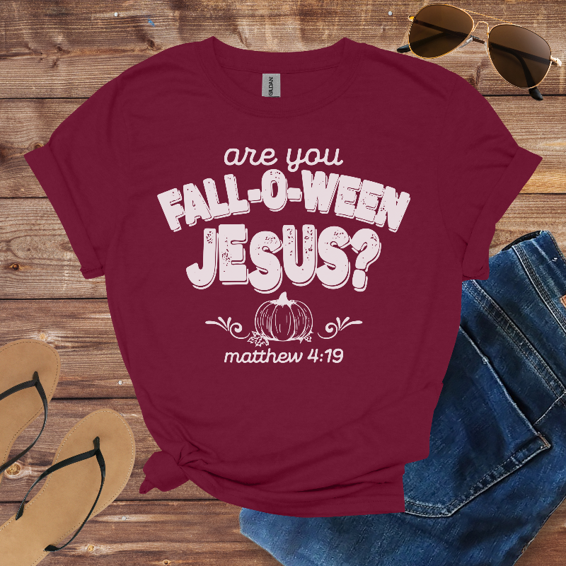 Maroon t-shirt with 'are you Fall-o-ween Jesus?' text on a wooden surface with sunglasses, jeans, and flip-flops.