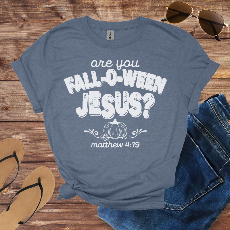 Blue t-shirt with 'are you Fall-O-Ween Jesus?' text on a wooden surface with sunglasses, jeans, and flip-flops.