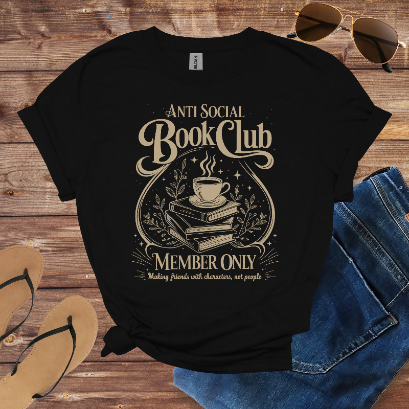 Black t-shirt with 'Anti Social Book Club' design on a wooden surface with sunglasses, jeans, and sandals.