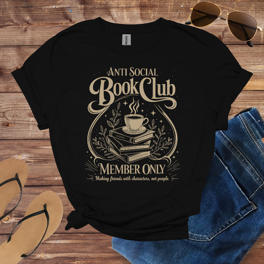 Black t-shirt with 'Anti Social Book Club' design on a wooden surface with sunglasses, jeans, and sandals.