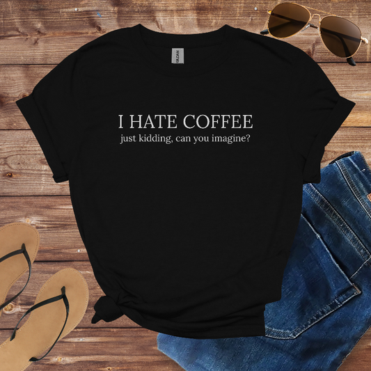 Black t-shirt with humorous text on a wooden surface with sunglasses, jeans, and flip-flops.